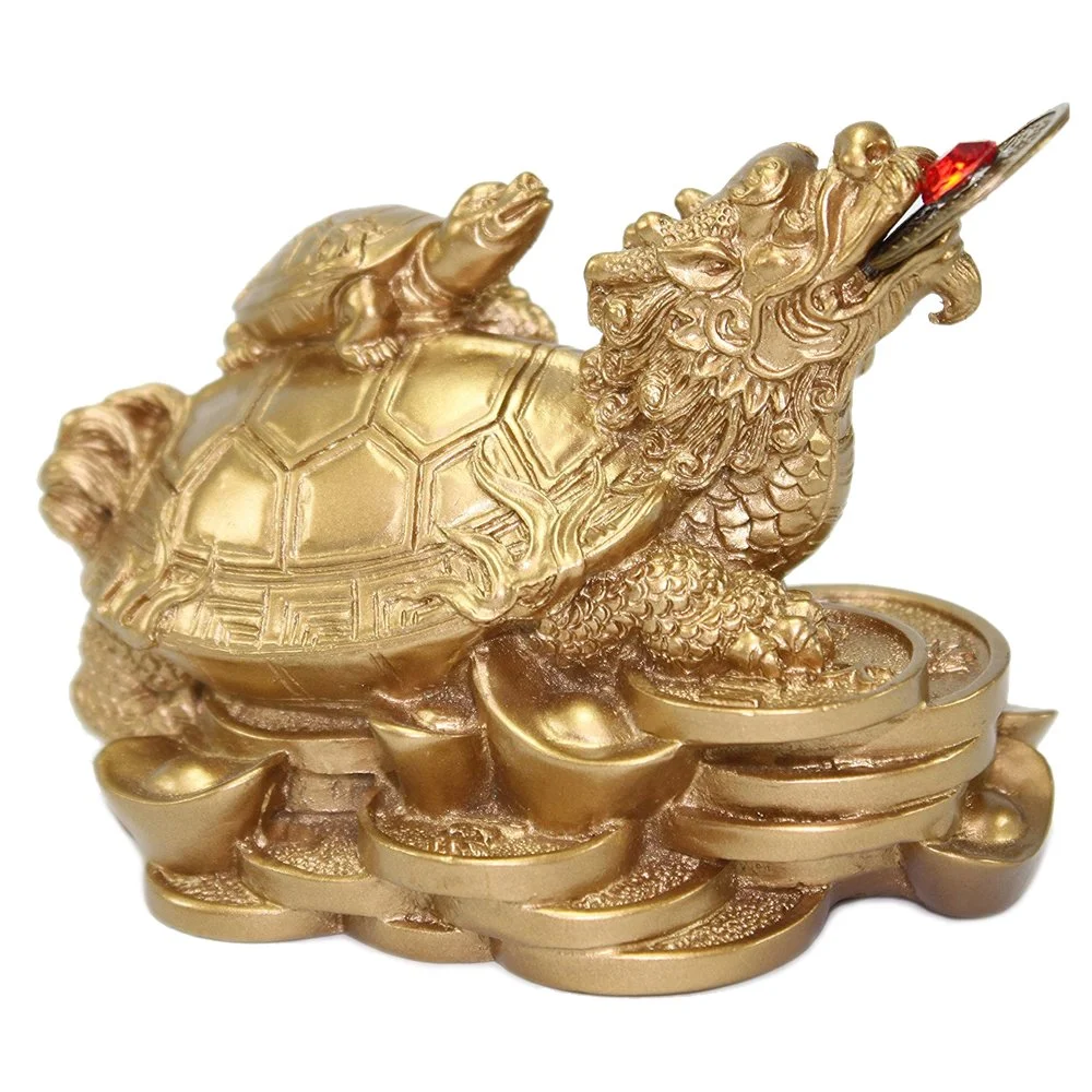 Golden Feng Shui Dragon Turtle statue with a coin in its mouth, sitting atop gold ingots and coins, symbolizing wealth, protection, and prosperity