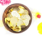 Laxmi Kubera Coins A set of 27 gold-plated Lakshmi Kubera Coins arranged neatly, used for Vastu remedies, Lakshmi puja, and wealth attraction, engraved with divine symbols of Goddess Lakshmi and Lord Kubera.